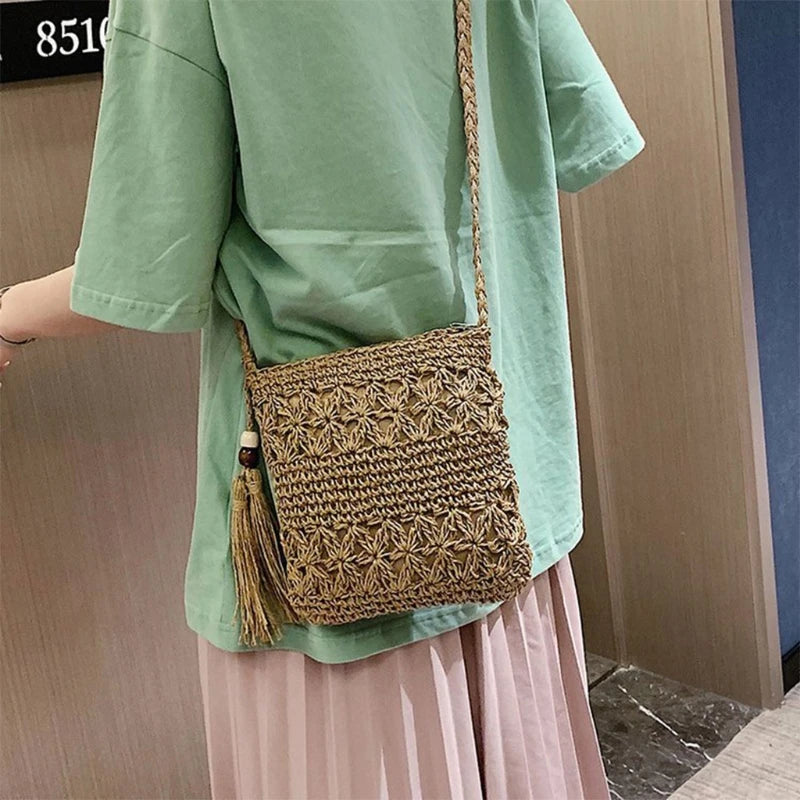 Person wearing a green shirt and pink skirt with a woven brown bag.