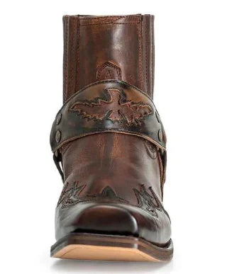 Brown leather boot with decorative strap and embossing on a white background