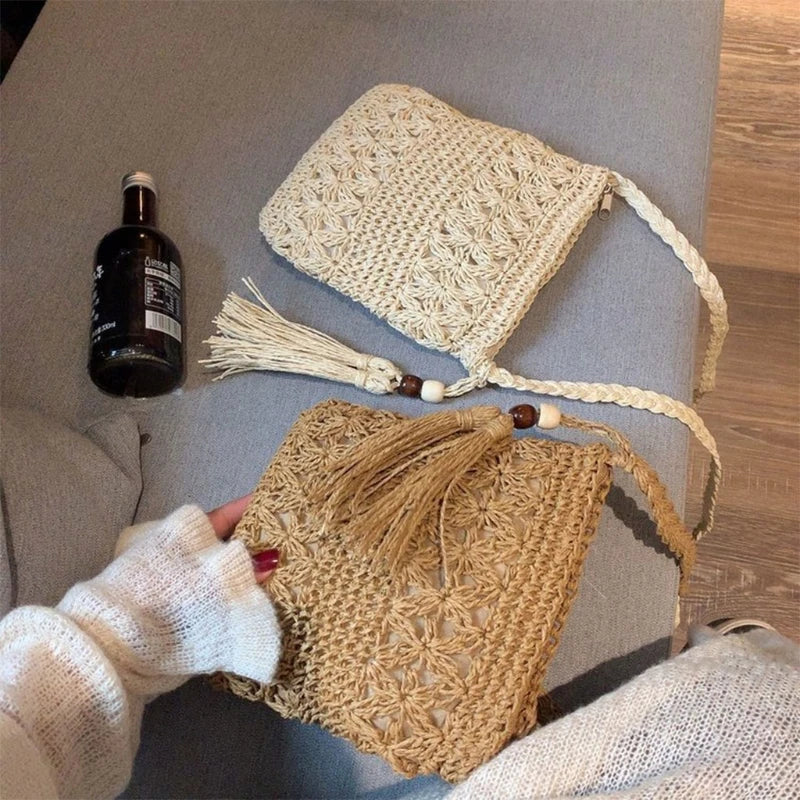 Handmade crochet bags with tassels on a gray surface, next to a bottle.
