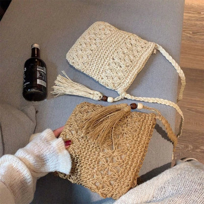 Handmade crochet bags with tassels on a gray surface, next to a bottle.
